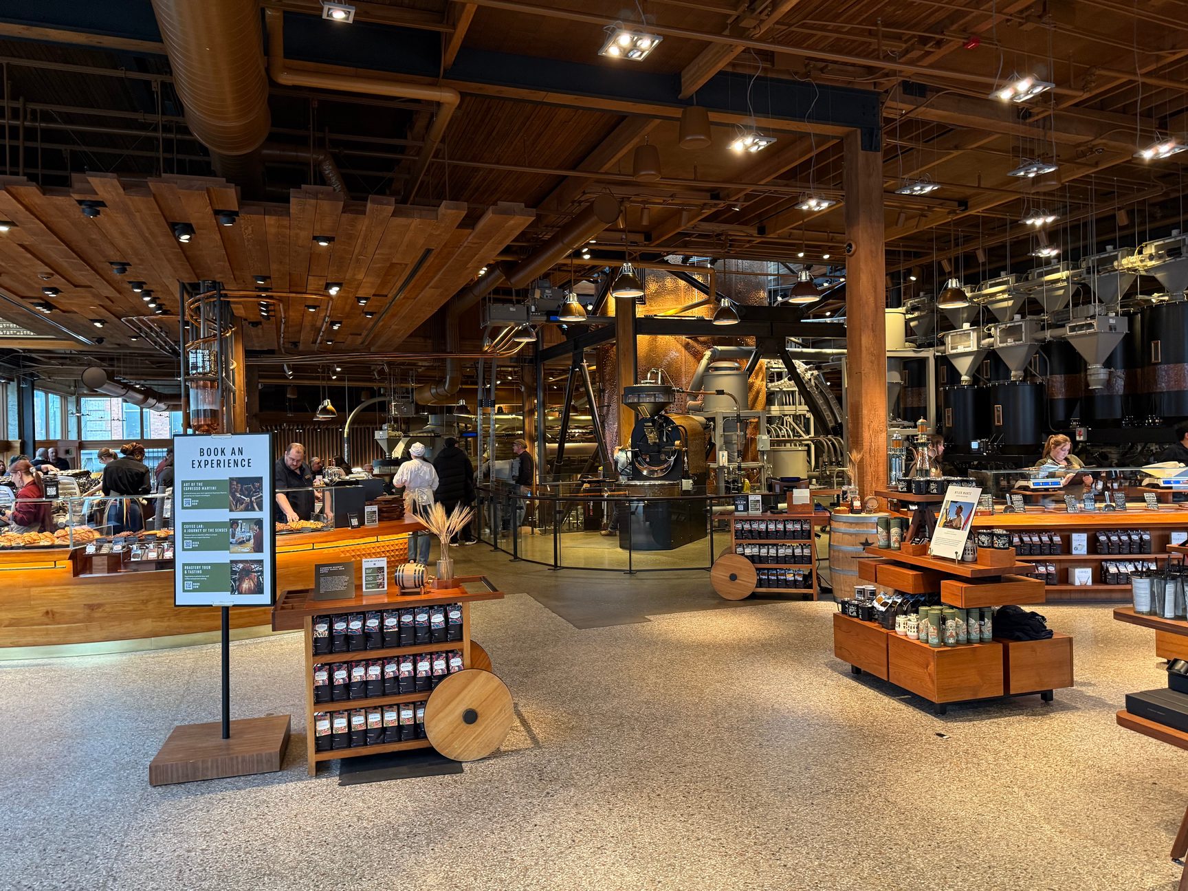 The Seattle Roastery interior, with roasting machinery behind the bakery and coffee counters beneath a timber ceiling.